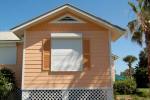 Orange house with windows shuttered for Hurricane season in Florida