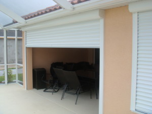 Peach-colored home with white roll-down shutters.