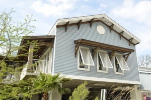 Light blue two-story home with Bahama shutters.
