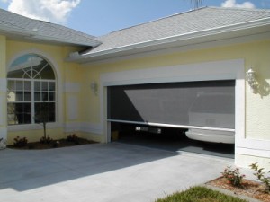 Residential garage door with a mesh screen installed.