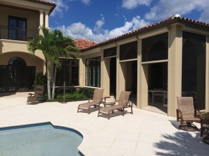 Large home with retractable hurricane screens installed around the patio.
