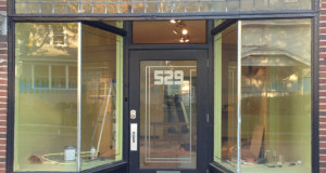 Retail store under remodel with large storefront windows.