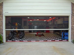 Residential garage is transformed into a hobby space thanks to a garage door screen installation.